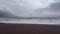 Camera motion along the seaside in slight storm. Great waves, brown sandy beach