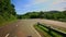 Camera moves along country curvy road among hilly landscape