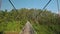 Camera Moves along Suspension Bridge over River in Park