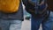 Camera moves around happy relaxed young romantic tourist couple with casual backpacks walking together on a winter day.