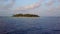 The camera moves away from round tropical atoll island resort hotel with white sand palm trees over turquoise Indian