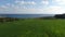 Camera moves forwards along green meadow to gorgeous blue Mediterranean Sea under sunny sky. Wide shot landscape of
