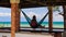 Camera Moves to Girl in Hammock in Red Roof Pavilion on Beach