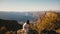 Camera moves up above peaceful young woman sitting at epic sunset panorama to reveal majestic Grand Canyon skyline.