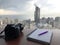 Camera and notebook on table with a beautiful view of the city in the background