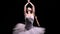 Camera rotates around two flexible ballerinas in black and white tutus move their hands dramatically against a backlit