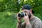 The camera smokes in the hands of photographer takes a photo in nature. young bearded man photographs outdoors