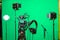 The camera on the tripod, led floodlight, headphones and a directional microphone on a green background. The chroma key