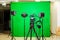 The camera on the tripod, led floodlight, headphones and a directional microphone on a green background. The chroma key