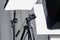 Camera tripod in a photo studio with lightning equipment