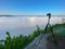 A camera with a tripod at sunrise looks at a foggy canyon.