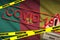 Cameroon flag and Covid-19 quarantine yellow tape with red stamp. Coronavirus or 2019-nCov virus