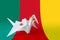 Cameroon flag depicted on paper origami crane wing. Handmade arts concept