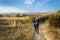 Camino de Santiago, Spain - Pilgrims Hiking through Countryside Past a Waymark Post along the Way of St James Camino de Santiago