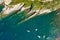 Camogli rocky coast aerial view. Boats and yachts moored near harbor with green water