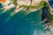 Camogli rocky coast aerial view. Boats and yachts moored near harbor with green water.