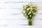 Camomile bouquet on white wooden background