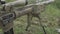 Camouflage sniper rifle is on the ground in the grass. airsoft guns