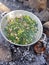 Camp cooking in the field on open fire - a big pan with vegtables and edible wild plants