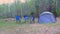 Camp tent, chairs, table and campfire in forest camping, nature trip at Summer.