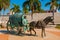 CAMPECHE, MEXICO: Statue of a horse drawn carriage in San Francisco de Campeche. A man sitting in a wagon with a barrel. next to t