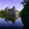 Campeneac, Brittany / France - 26 August 2019: Trecesson Castle reflected in the pond and surrounded by forest