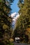 Camper at Baker Lake Road, surrounded by trees and snow-capped Baker Mountain in the background at North Cascades,