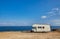 Camper rv caravan on mediterranean coast in Italy. Wild camping on sea shore