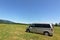 A camper van in a meadow with trees view