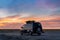 Camper van parked in a beachfront parking lot under an amazing sunset sky in southern Spain