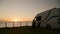 Camper van parked on coast with beautiful seafront sunset view, campin