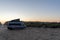 Camper van parked at an idyllic beach access at sunrise