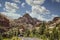 Camper van rounding curve in two-lane road through towering layered cliffs of Zion National Park in Utah USA on pretty sunny day