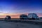 Camper vans parked in a beachfront parking lot under an amazing sunset sky in southern Spain