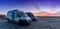 Camper vans parked in a beachfront parking lot under an amazing sunset sky in southern Spain