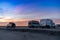 Camper vans parked in a beachfront parking lot under an amazing sunset sky in southern Spain