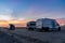 Camper vans parked in a beachfront parking lot under an amazing sunset sky in southern Spain