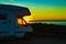 Camper vehicle on beach at sunrise