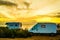 Camper vehicles on beach at sunrise