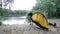 Campers putting up tent, preparing to overnight in wild, green tourism, hiking. Happy travels concept.