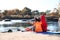 Campers sitting in sleeping bags on wild beach.