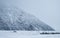 A campervan driving on the road in a snowy day. Mount Cook Village valley