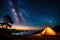 A campfire burning bright under a starry night sky, with tents pitched nearby for a cozy camping experience