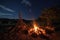 campfire crackling in the night sky, with view of the harvest moon shining its light