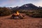 Campfire flames in rock fire pit in desert at base of mountains