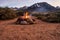 Campfire flames in rock fire pit in desert at base of mountains