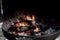 Campfire in metal container, fire ring closeup of burning logs and bright flames of fire