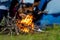 Campfire at touristic camp at nature in outdoor forest, flame and  fire sparks.  Group friend background.