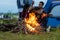 Campfire at touristic camp at nature in outdoor forest, flame and  fire sparks.  Group friend background