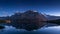 Campfire under the stars in front of Ecrins National Park massif with La Meije peak. Lac du Pontet, Alps, France